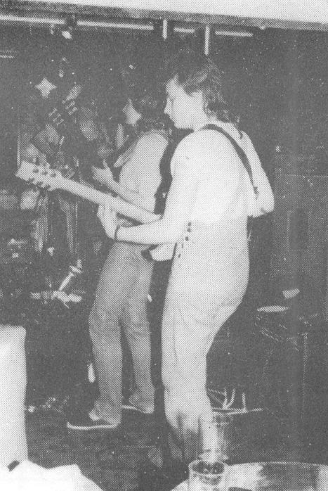 Bad Habits1 Very blurry old photo of two of the Bad Habits on stage, audience behind guitarists.