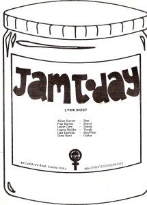 A small white booklet of lyrics bearing the Jam Today logo of a black and white drawing of a jam jar and a WLM symbol of a women's symbol and clenched fist, and the list of band members.