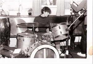 Josefina in rehearsal with the Guest Stars, seated at her drum kit and focusing seriously on playing.