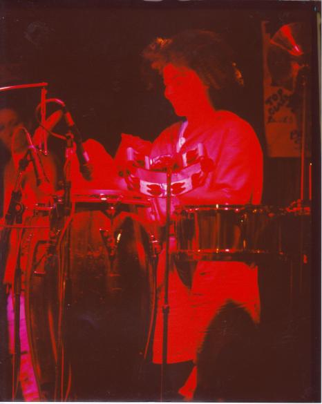 Meet Your Feet's percussionist, playing congas drums on stage.