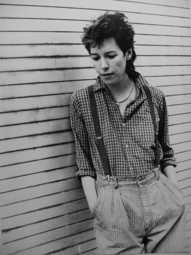 Black and white photo of Penny Wood, wearing checked shirt and braces, looking at the floor.