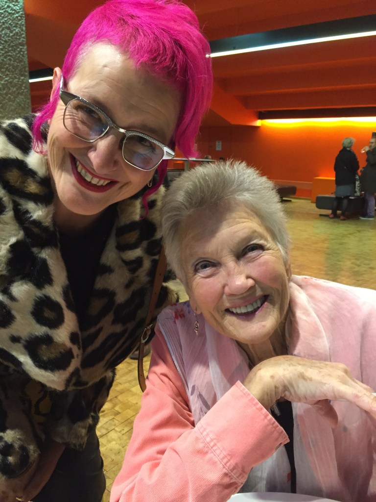 Peggy smiling after concert at Barbican, Rachael House with arm around her shoulder, both smiling.