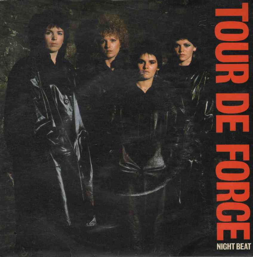 Colour photo of the band, all dressed in black leather on a black back ground. Stern expressions, looking confidently at the camera. 'Tour de Force' written in bold red letters down the right hand margin.