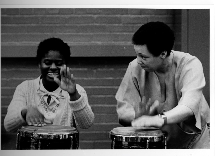 Terri Quaye and a student playing conga drums in a workshop for disability charity Scope, 1983