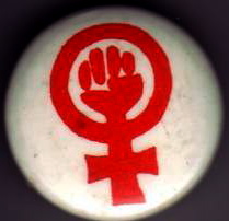A photo of the WLM badge, with its red symbol of a clenched fist inside a women's symbol, on a white background.